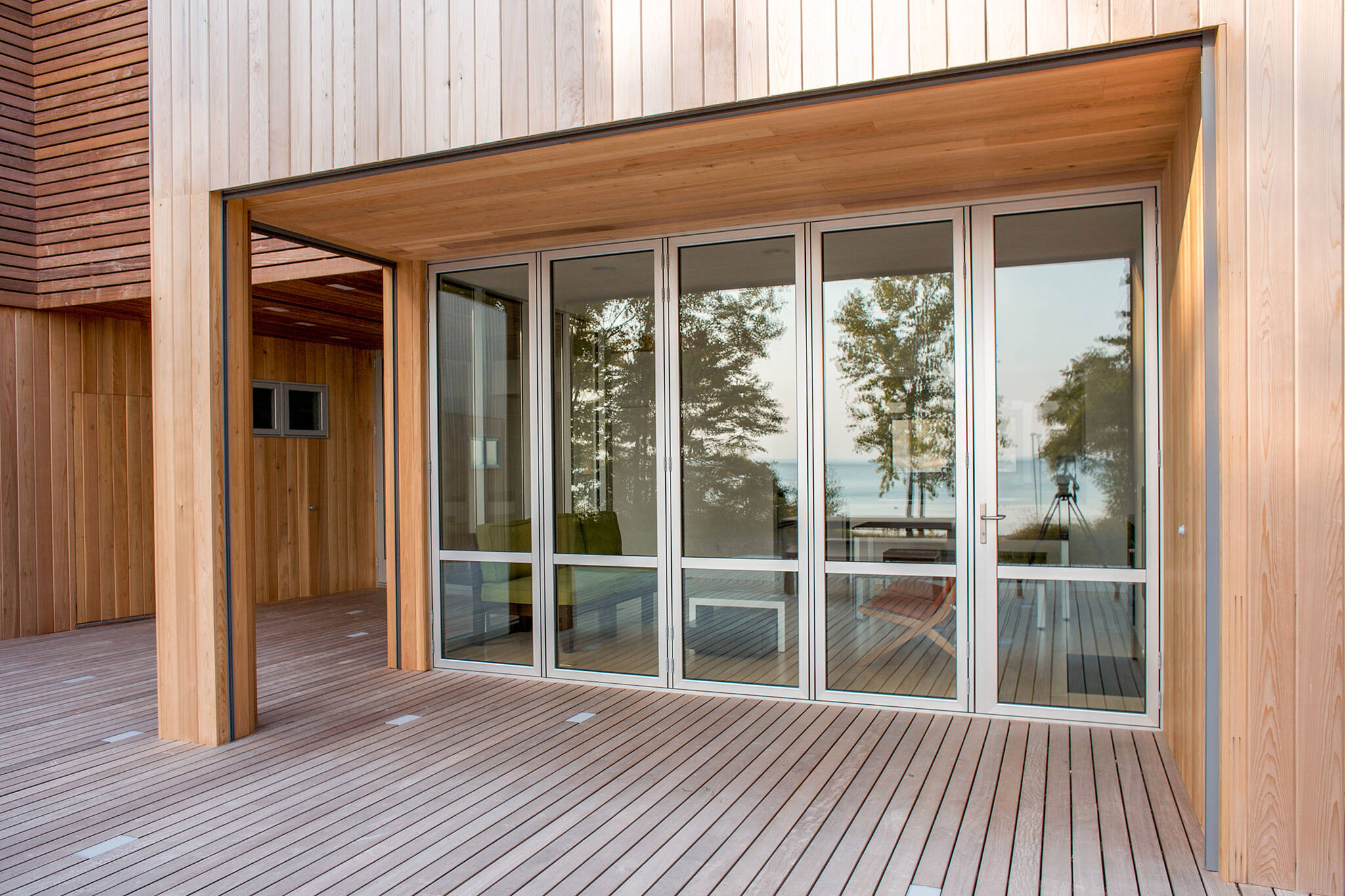 Deck folding doors sequence of the sustainable lake house project in Omena, Michigan designed by the architecture studio Danny Forster & Architecture