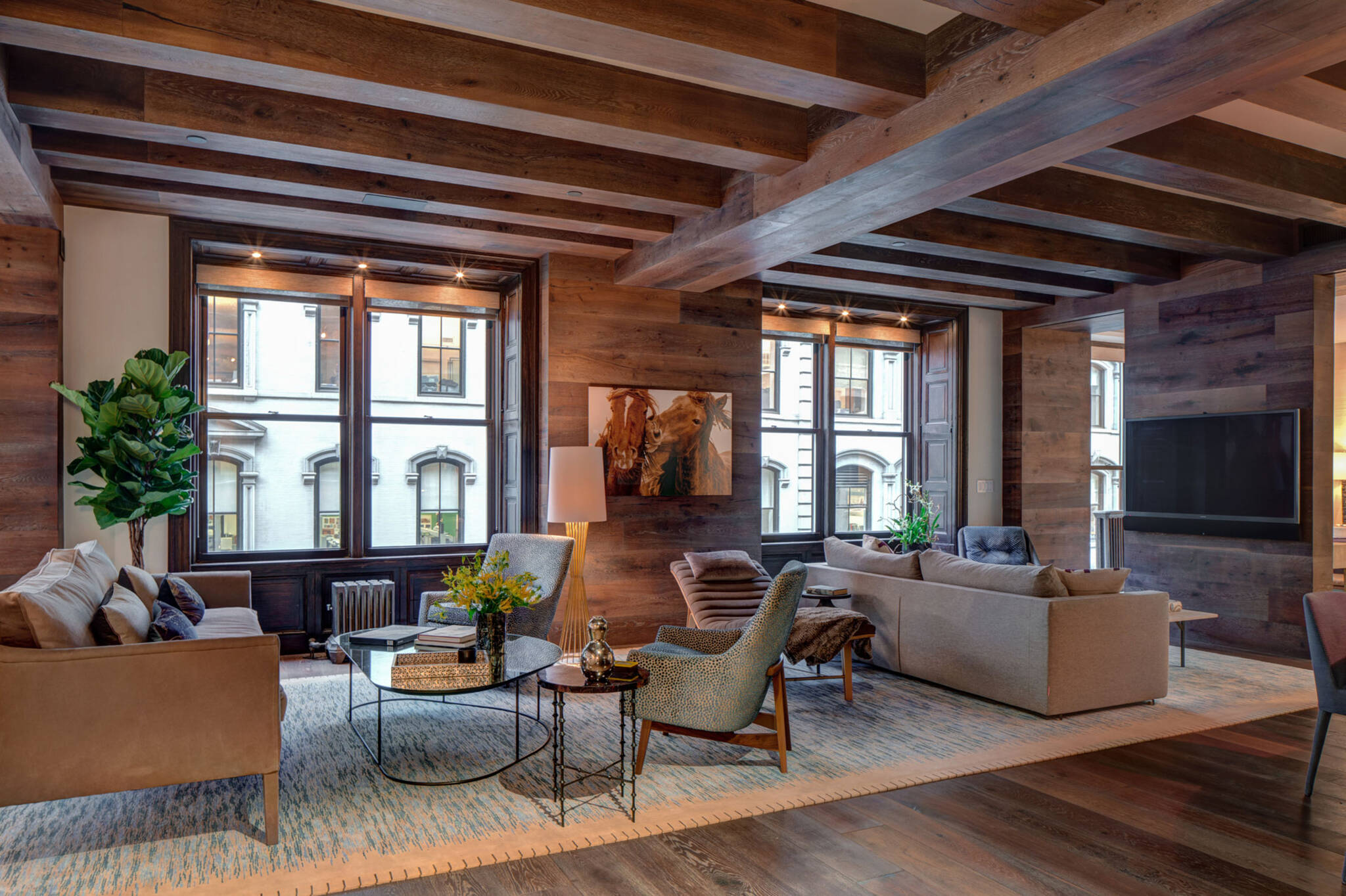 Living room under the wooden beam and cross beams ceiling of the loft renovation project in Union Square, New York City designed by the architecture studio Danny Forster & Architecture